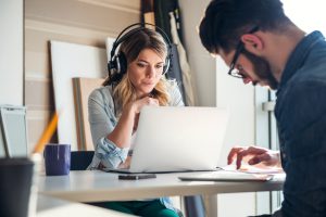Young woman listening to the music while working in an office.